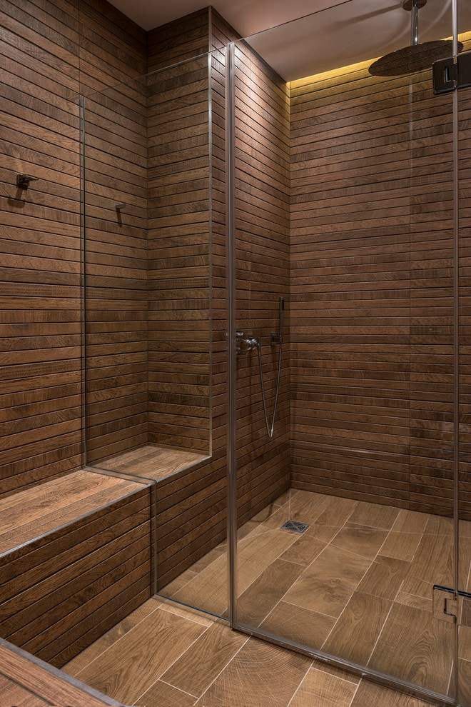 Imagen de cuarto de baño actual pequeño con puertas de armario de madera en tonos medios, ducha abierta, paredes marrones, suelo de madera oscura y aseo y ducha