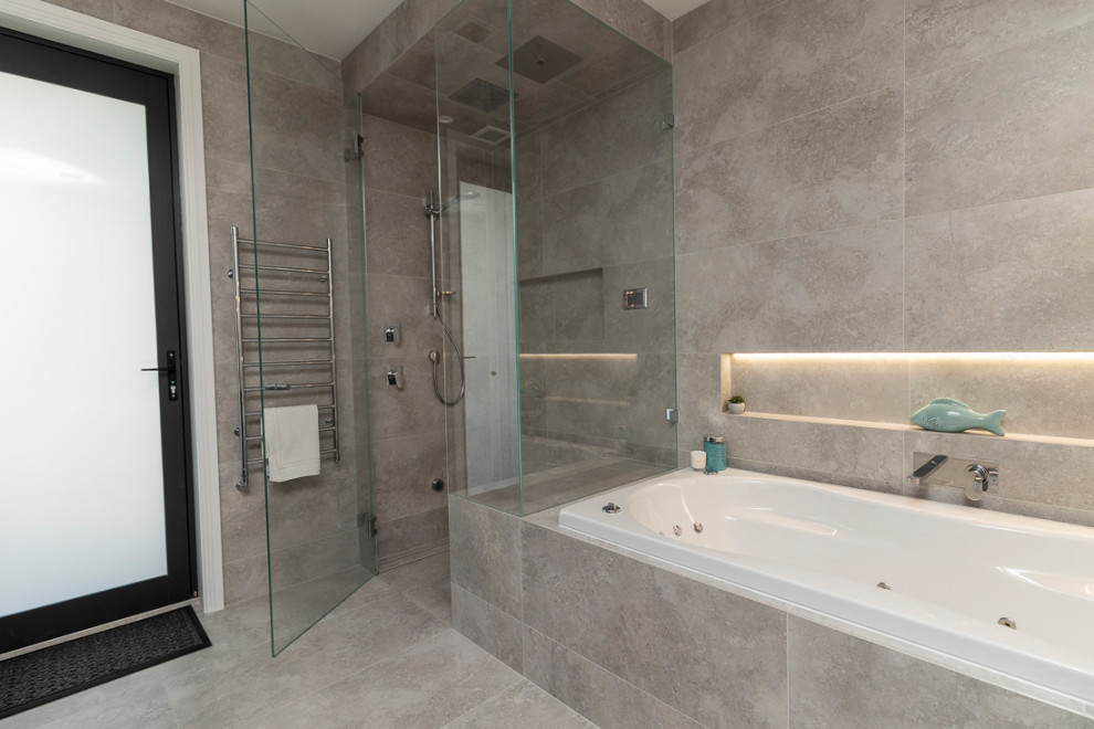 Design ideas for an expansive modern shower room bathroom in Sydney with flat-panel cabinets, dark wood cabinets, a freestanding bath, a walk-in shower, a wall mounted toilet, grey tiles, porcelain tiles, multi-coloured walls, porcelain flooring, a submerged sink, tiled worktops, grey floors, an open shower and white worktops.