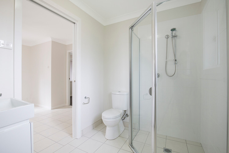 Idéer för ett litet modernt badrum, med vita skåp, en dusch i en alkov, en toalettstol med hel cisternkåpa, vit kakel, keramikplattor, vita väggar, klinkergolv i keramik, ett integrerad handfat och granitbänkskiva