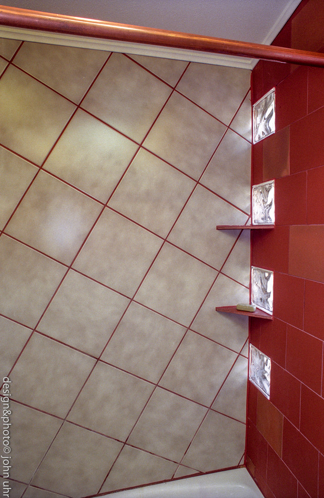 Modelo de cuarto de baño principal bohemio grande con armarios tipo vitrina, puertas de armario negras, bañera encastrada, combinación de ducha y bañera, sanitario de una pieza, baldosas y/o azulejos rojos, paredes rojas, suelo de baldosas de porcelana, lavabo sobreencimera y encimera de granito