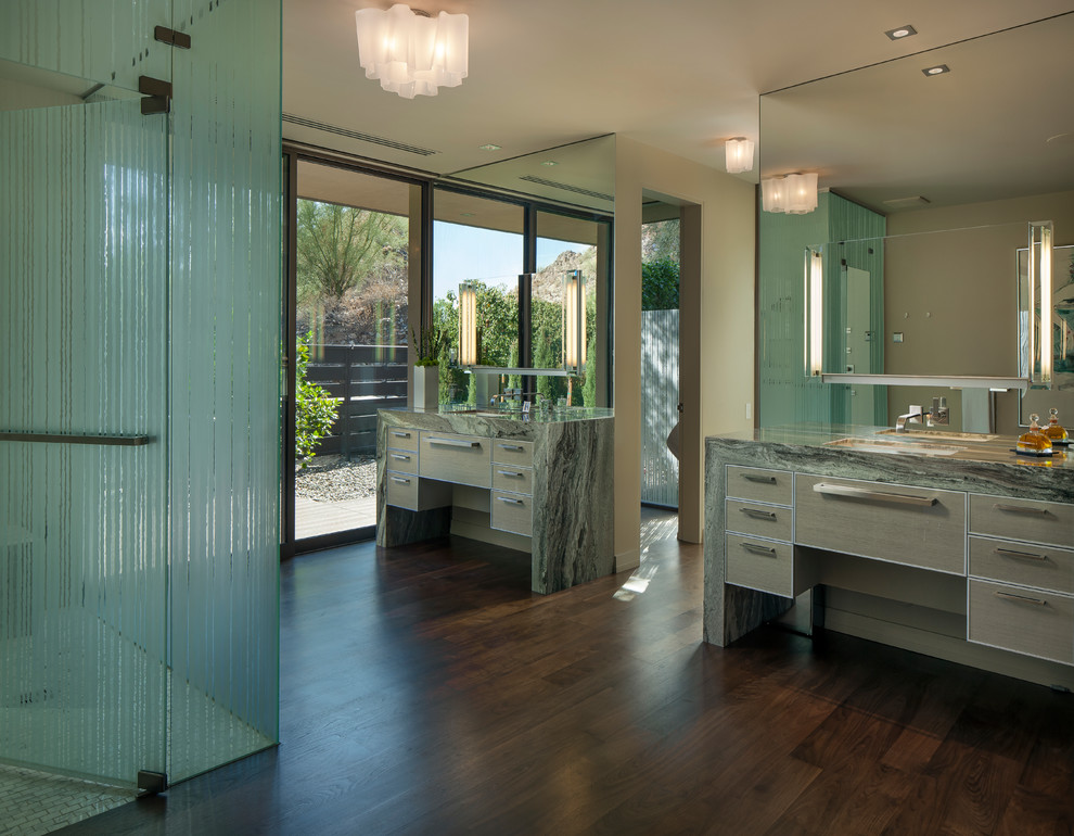Réalisation d'une salle de bain design avec un lavabo encastré, un placard à porte plane, une douche d'angle, un mur beige et parquet foncé.