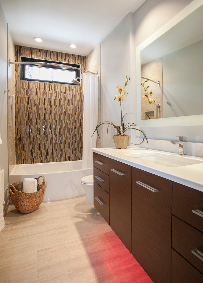 Cette photo montre une salle de bain tendance en bois foncé de taille moyenne avec un placard à porte plane, un combiné douche/baignoire, WC suspendus, un carrelage beige, un carrelage en pâte de verre, un mur gris, un sol en carrelage de porcelaine, un lavabo encastré et un plan de toilette en quartz modifié.