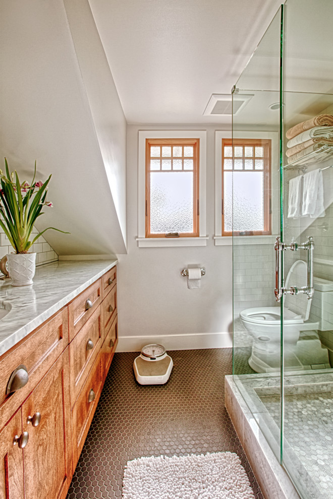 Small arts and crafts master white tile and ceramic tile ceramic tile and gray floor corner shower photo in Seattle with shaker cabinets, medium tone wood cabinets, a two-piece toilet, white walls, an undermount sink, quartz countertops, a hinged shower door and white countertops