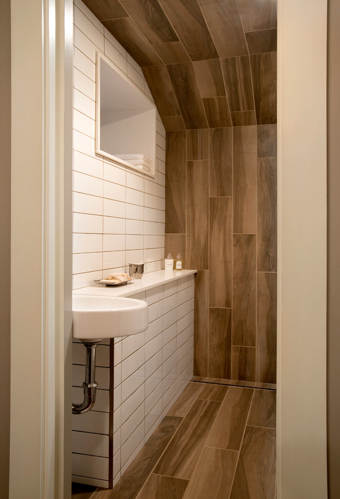 Bild på ett litet funkis badrum med dusch, med en kantlös dusch, en vägghängd toalettstol, flerfärgad kakel, porslinskakel, vita väggar, klinkergolv i porslin, ett väggmonterat handfat och bänkskiva i kvarts