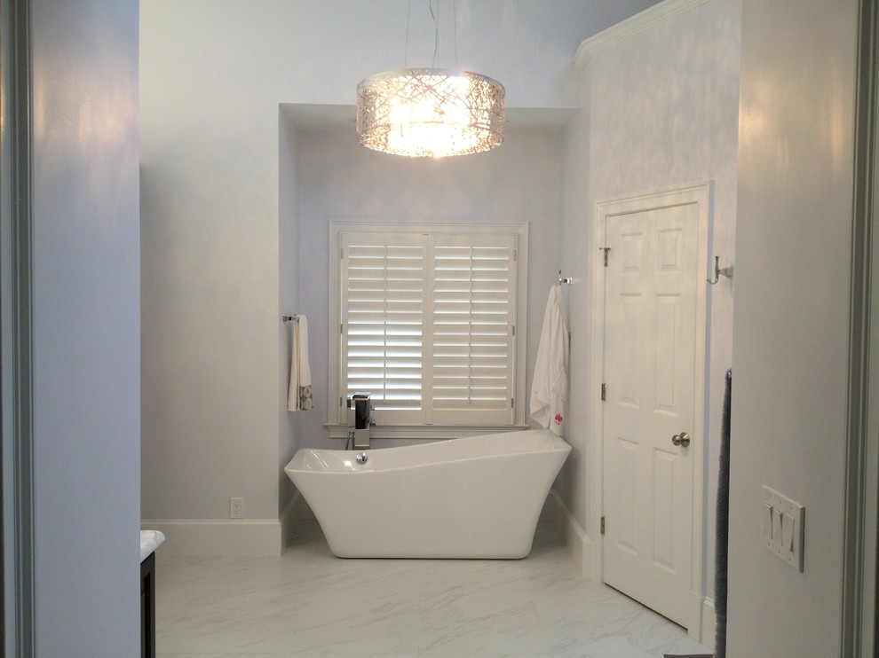 Bild på ett stort funkis en-suite badrum, med ett undermonterad handfat, ett fristående badkar, en hörndusch, vit kakel, keramikplattor, luckor med upphöjd panel, svarta skåp, en toalettstol med separat cisternkåpa, vita väggar, marmorgolv och marmorbänkskiva