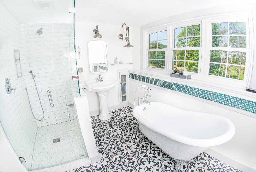 Foto på ett litet vintage badrum, med ett badkar med tassar, en hörndusch, en toalettstol med separat cisternkåpa, keramikplattor, vita väggar, klinkergolv i keramik, ett piedestal handfat, flerfärgat golv och dusch med gångjärnsdörr