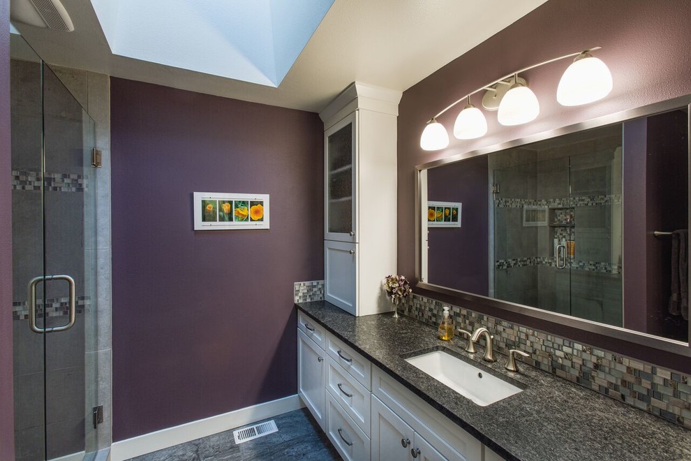 Cette image montre une salle de bain traditionnelle de taille moyenne avec un placard à porte shaker, des portes de placard blanches, un carrelage en pâte de verre, un mur violet, un lavabo encastré, un sol en carrelage de céramique, un sol gris et une cabine de douche à porte battante.