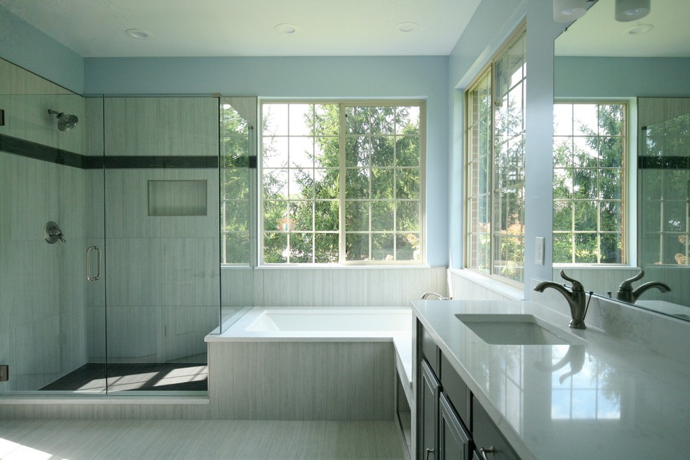 Exempel på ett klassiskt badrum, med ett undermonterat badkar, grå kakel, porslinskakel, blå väggar, klinkergolv i porslin, bänkskiva i kvarts, grått golv och dusch med gångjärnsdörr