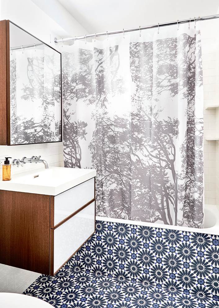 Small trendy multicolored tile multicolored floor and concrete floor bathroom photo in New York with flat-panel cabinets, white walls, a drop-in sink, white cabinets, a one-piece toilet and quartz countertops