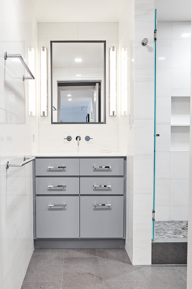 Small contemporary ensuite bathroom in New York with flat-panel cabinets, grey cabinets, a one-piece toilet, multi-coloured tiles, stone tiles, white walls, a submerged sink, an alcove shower, marble flooring and marble worktops.