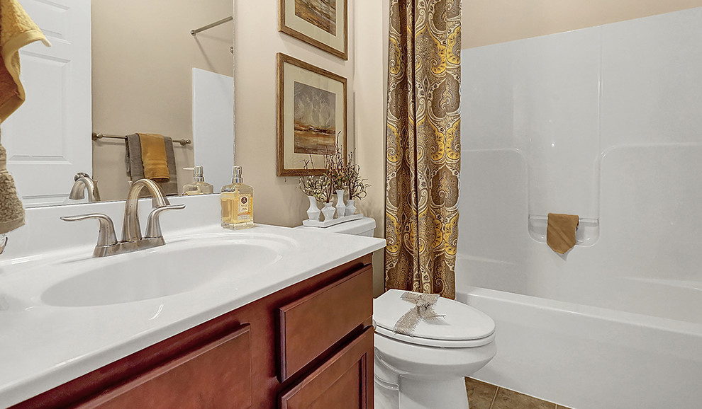 Foto de cuarto de baño clásico de tamaño medio con combinación de ducha y bañera, sanitario de dos piezas, paredes beige, suelo de baldosas de cerámica, encimera de mármol y ducha con cortina