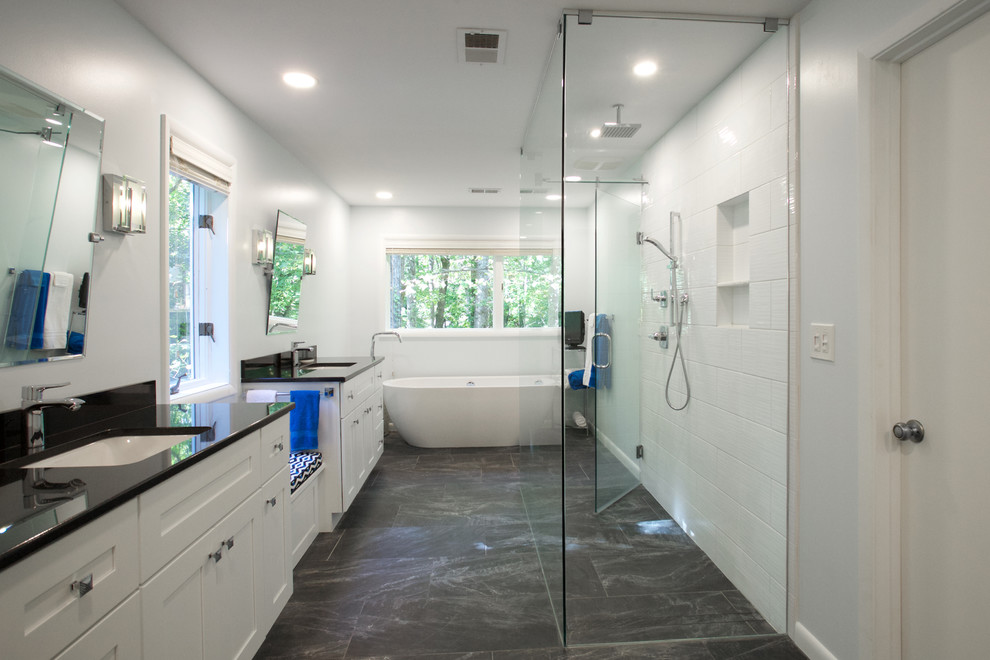 Example of a large trendy master white tile and ceramic tile slate floor and gray floor bathroom design in Atlanta with recessed-panel cabinets, white cabinets, white walls, an undermount sink, marble countertops, a hinged shower door and black countertops