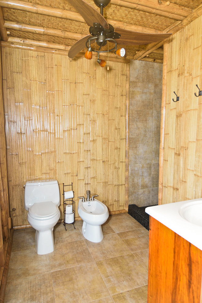 Immagine di una stanza da bagno tropicale con doccia alcova, bidè, piastrelle beige e pavimento con piastrelle in ceramica