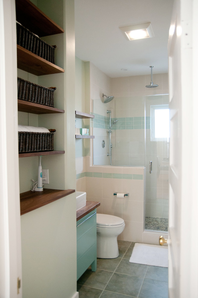 Inspiration for a mid-sized mid-century modern 3/4 multicolored tile and porcelain tile porcelain tile alcove shower remodel in Boston with a vessel sink, recessed-panel cabinets, blue cabinets, wood countertops, a one-piece toilet and green walls