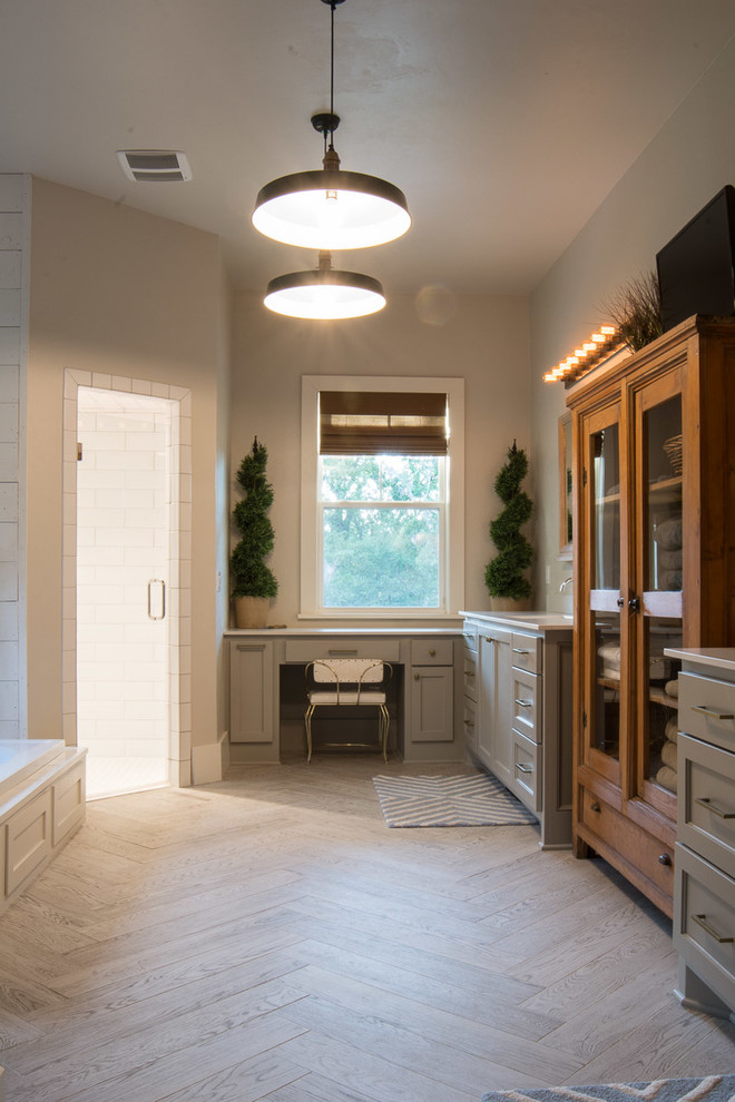Large cottage master white tile and subway tile light wood floor and brown floor bathroom photo in Oklahoma City with recessed-panel cabinets, gray cabinets, gray walls, an undermount sink, quartz countertops and a hinged shower door