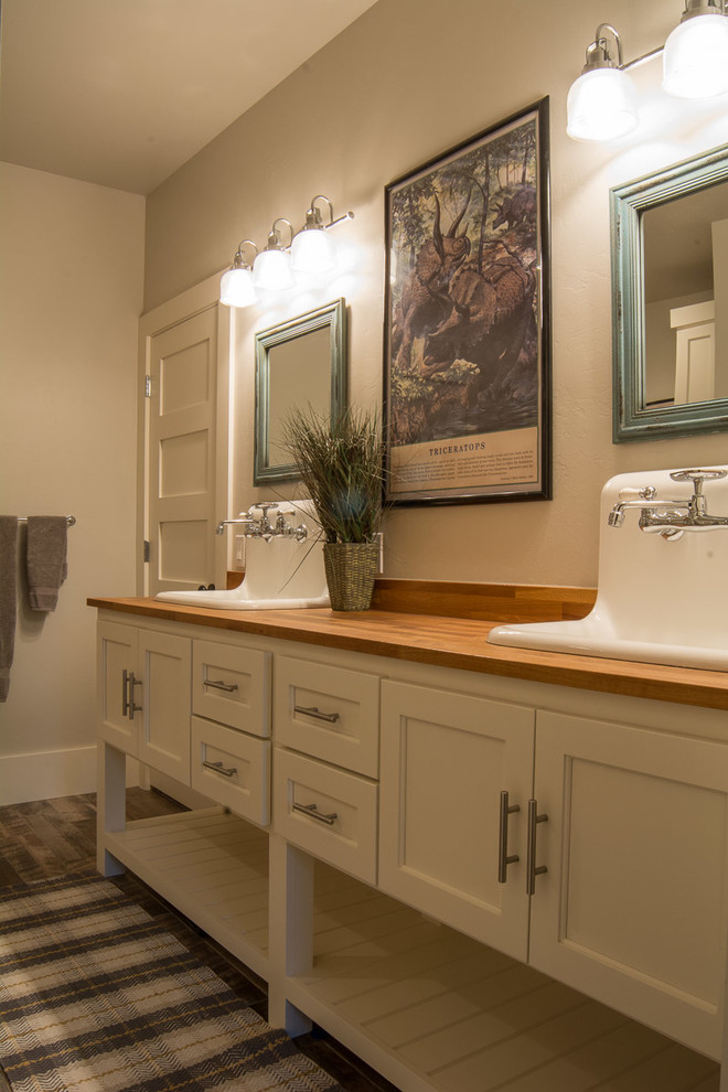 Large country 3/4 brown floor and medium tone wood floor bathroom photo in Oklahoma City with recessed-panel cabinets, gray walls, white cabinets, a drop-in sink and wood countertops