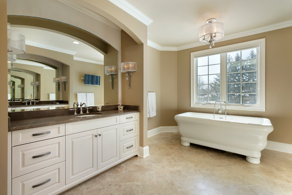Mittelgroßes Klassisches Badezimmer En Suite mit Unterbauwaschbecken, profilierten Schrankfronten, weißen Schränken, beiger Wandfarbe, freistehender Badewanne und Keramikboden in Chicago