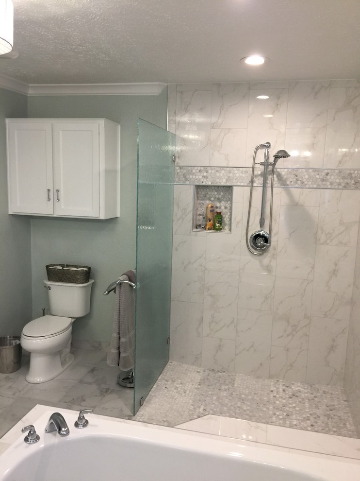 Inspiration for a large contemporary ensuite bathroom in Dallas with recessed-panel cabinets, white cabinets, a built-in bath, a corner shower, a two-piece toilet, grey walls, marble flooring, a submerged sink, marble worktops, grey floors and a hinged door.