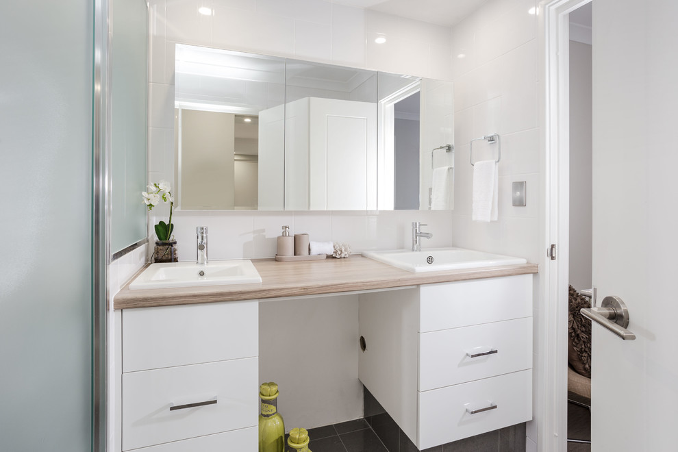 Walk-in shower - small contemporary master black tile and ceramic tile ceramic tile walk-in shower idea in Perth with flat-panel cabinets, white cabinets, a one-piece toilet, white walls, a trough sink and quartz countertops