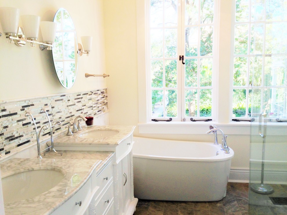 Свежая идея для дизайна: ванная комната в стиле неоклассика (современная классика) с врезной раковиной, фасадами островного типа, белыми фасадами, мраморной столешницей, отдельно стоящей ванной, угловым душем, унитазом-моноблоком и серой плиткой - отличное фото интерьера