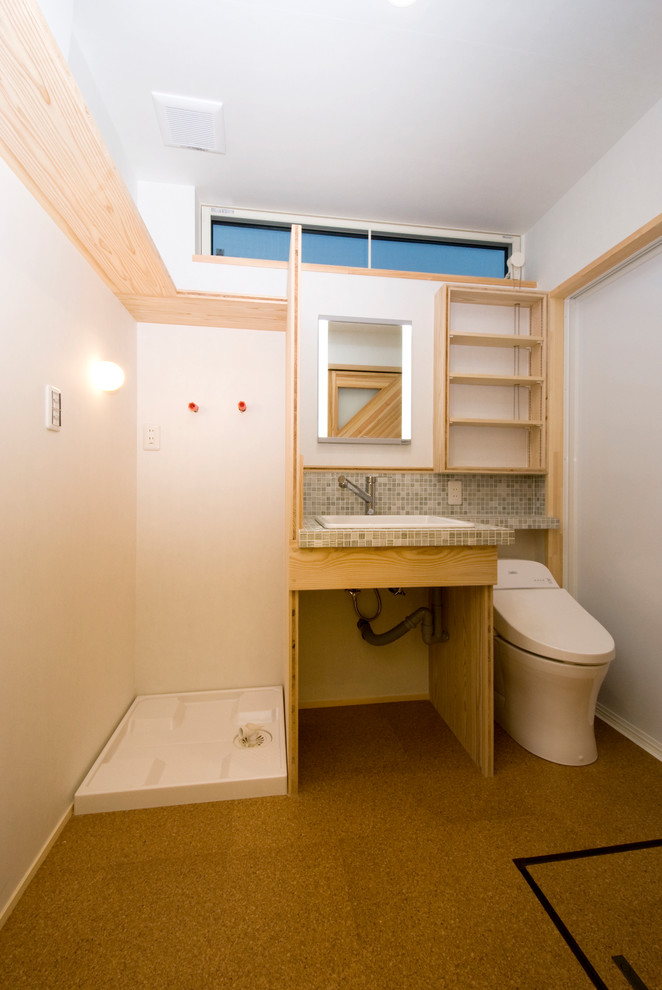 Rustik inredning av ett litet en-suite badrum, med öppna hyllor, skåp i ljust trä, ett japanskt badkar, en kantlös dusch, en toalettstol med hel cisternkåpa, vit kakel, mosaik, vita väggar, korkgolv, ett nedsänkt handfat, kaklad bänkskiva och beiget golv