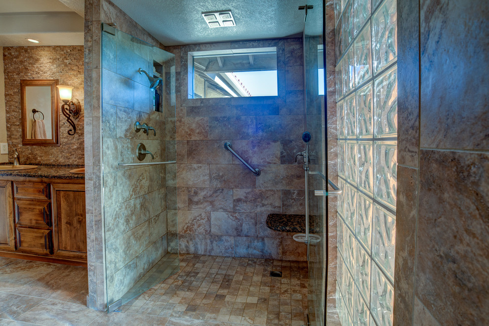 Inspiration for a large timeless master brown tile and stone tile ceramic tile and beige floor alcove shower remodel in Los Angeles with raised-panel cabinets, medium tone wood cabinets, a two-piece toilet, beige walls, a drop-in sink, granite countertops and a hinged shower door