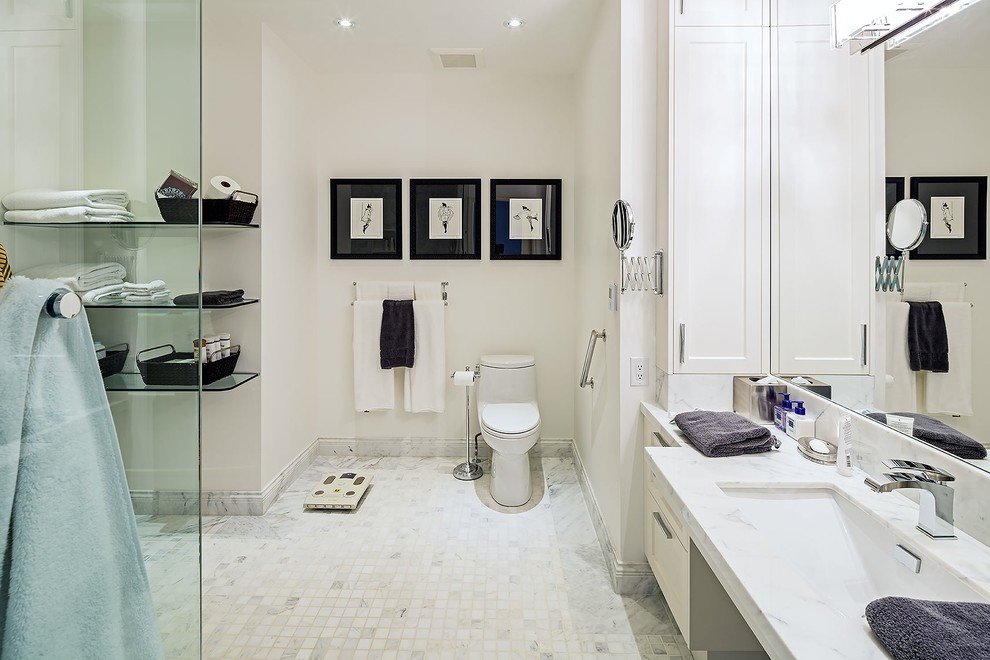 This is an example of a large traditional ensuite bathroom in Toronto with a submerged sink, white cabinets, a one-piece toilet, white tiles, white walls, recessed-panel cabinets, marble worktops, cement tiles, ceramic flooring and white worktops.