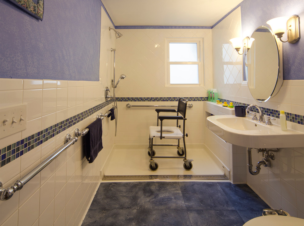 Klassisk inredning av ett mellanstort badrum, med ett väggmonterat handfat, en kantlös dusch, glaskakel, blå väggar och vinylgolv