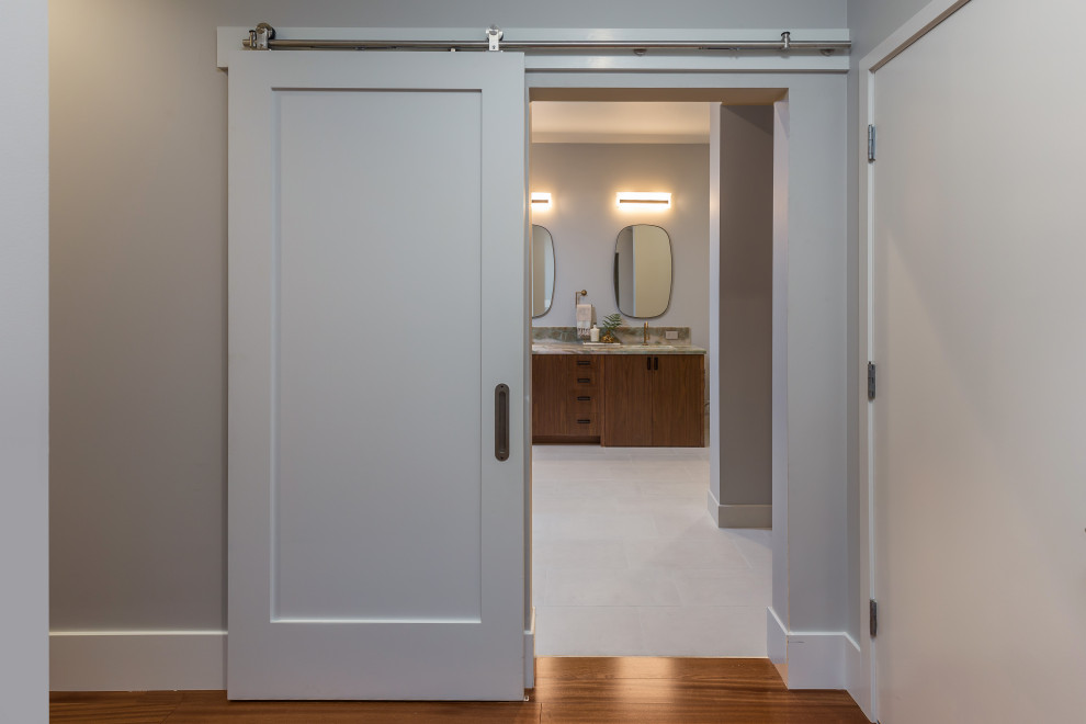 Стильный дизайн: большая главная ванная комната в стиле модернизм с плоскими фасадами, коричневыми фасадами, открытым душем, биде, зеленой плиткой, плиткой из листового камня, серыми стенами, полом из винила, врезной раковиной, столешницей из кварцита, серым полом, душем с распашными дверями, зеленой столешницей, сиденьем для душа, тумбой под две раковины и встроенной тумбой - последний тренд