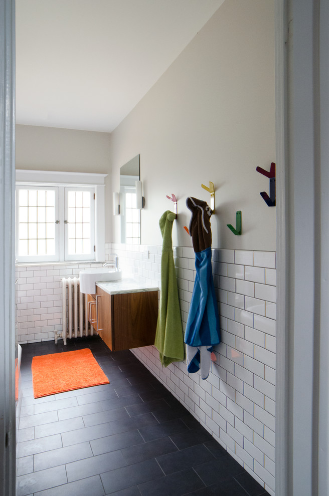 Exempel på ett mellanstort modernt vit vitt badrum för barn, med släta luckor, skåp i mörkt trä, ett hörnbadkar, en dusch/badkar-kombination, vit kakel, keramikplattor, beige väggar, klinkergolv i porslin, ett fristående handfat, marmorbänkskiva och grått golv