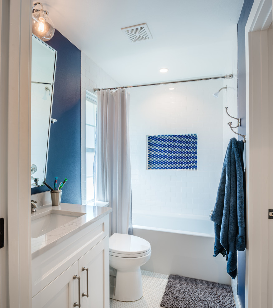 Inspiration for a medium sized traditional family bathroom in Denver with flat-panel cabinets, white cabinets, a corner bath, a shower/bath combination, a one-piece toilet, white tiles, mosaic tiles, blue walls, mosaic tile flooring, a built-in sink, white floors and a shower curtain.