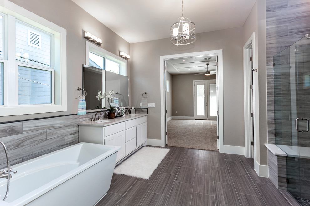 Design ideas for a large country ensuite bathroom in Austin with shaker cabinets, white cabinets, a freestanding bath, a built-in shower, a two-piece toilet, beige tiles, ceramic tiles, beige walls, ceramic flooring, a submerged sink, engineered stone worktops, grey floors, a hinged door and white worktops.