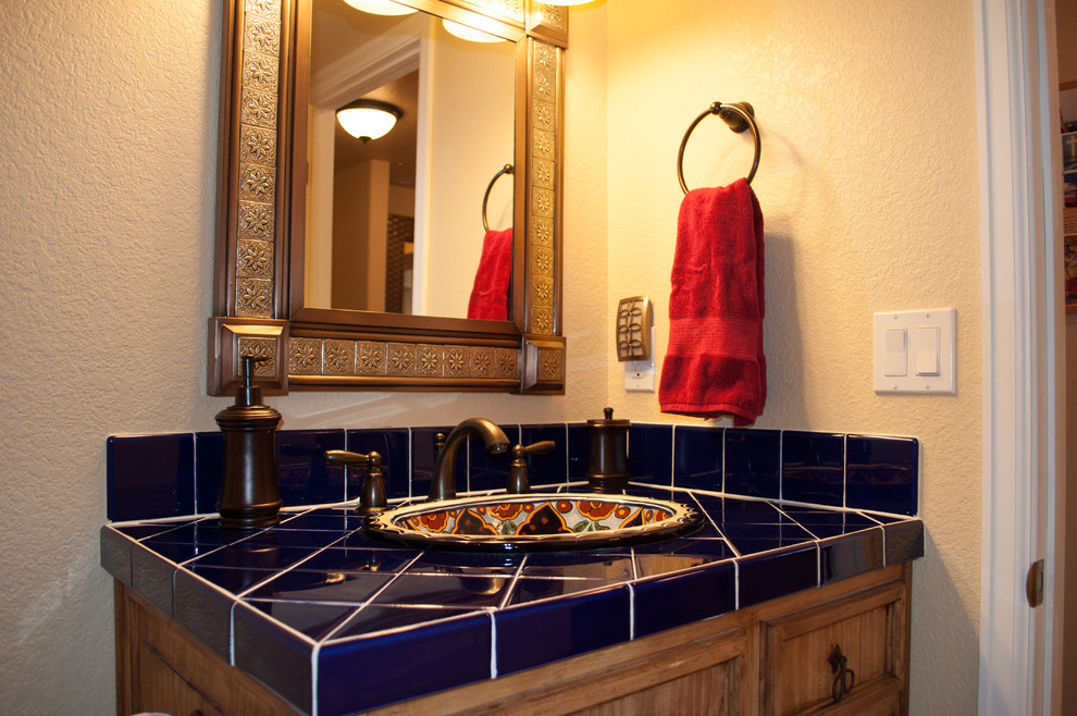 На фото: главная ванная комната среднего размера в стиле неоклассика (современная классика) с фасадами с утопленной филенкой, фасадами цвета дерева среднего тона, душем в нише, раздельным унитазом, синей плиткой, керамической плиткой, бежевыми стенами, полом из терракотовой плитки, накладной раковиной, столешницей из плитки, красным полом, душем с распашными дверями и синей столешницей с