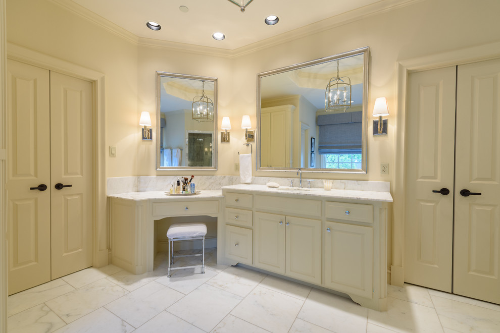 Example of a large classic master ceramic tile and white floor bathroom design in Dallas with raised-panel cabinets, beige cabinets, beige walls, an undermount sink, granite countertops, a hinged shower door and white countertops