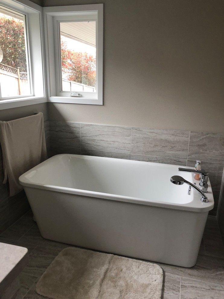 Example of a large transitional master gray tile and porcelain tile porcelain tile and gray floor bathroom design in Seattle with shaker cabinets, medium tone wood cabinets, a two-piece toilet, beige walls, a vessel sink, quartzite countertops, a hinged shower door and gray countertops