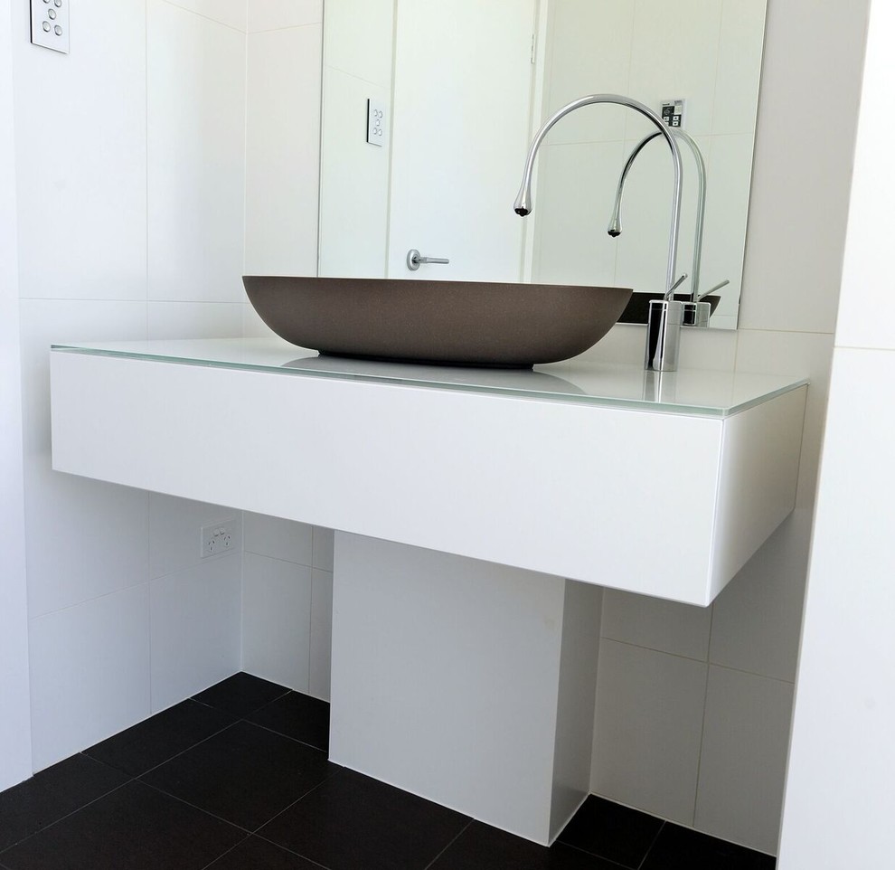 Esempio di una stanza da bagno design con ante lisce, ante bianche, pistrelle in bianco e nero, pareti bianche, lavabo a bacinella e top in vetro