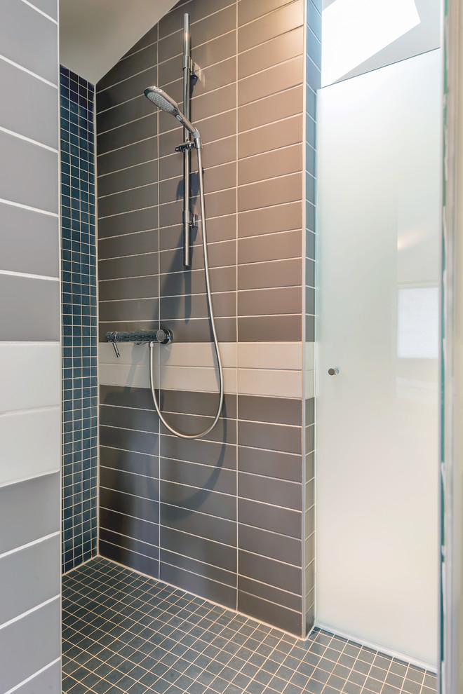 Inspiration för moderna en-suite badrum, med ett fristående handfat, släta luckor, vita skåp, bänkskiva i akrylsten, en kantlös dusch, en vägghängd toalettstol, grå kakel, keramikplattor, flerfärgade väggar och klinkergolv i keramik