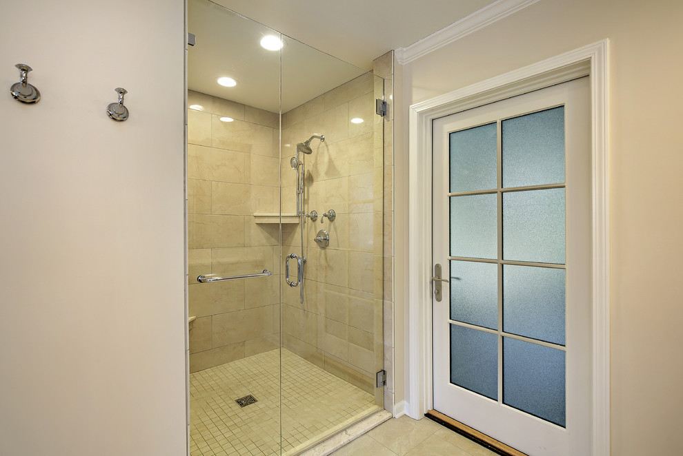 Inspiration for a large classic ensuite bathroom in Chicago with raised-panel cabinets, medium wood cabinets, a freestanding bath, an alcove shower, a two-piece toilet, beige tiles, porcelain tiles, beige walls, porcelain flooring, a submerged sink, beige floors, a hinged door and beige worktops.