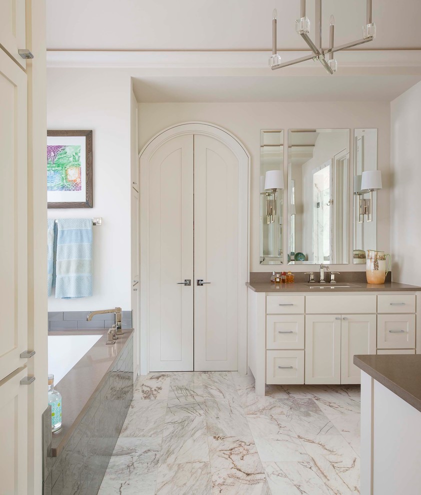 Esempio di una stanza da bagno padronale classica con ante in stile shaker, ante bianche, vasca sottopiano, pareti bianche, lavabo sottopiano, piastrelle grigie e top grigio