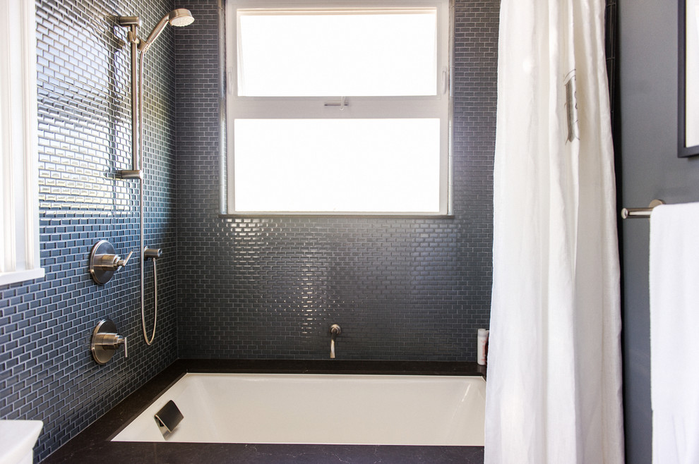 Aménagement d'une salle d'eau contemporaine de taille moyenne avec un placard à porte shaker, des portes de placard blanches, une baignoire en alcôve, un combiné douche/baignoire, WC séparés, un mur noir, un lavabo encastré, un plan de toilette en surface solide et une cabine de douche avec un rideau.