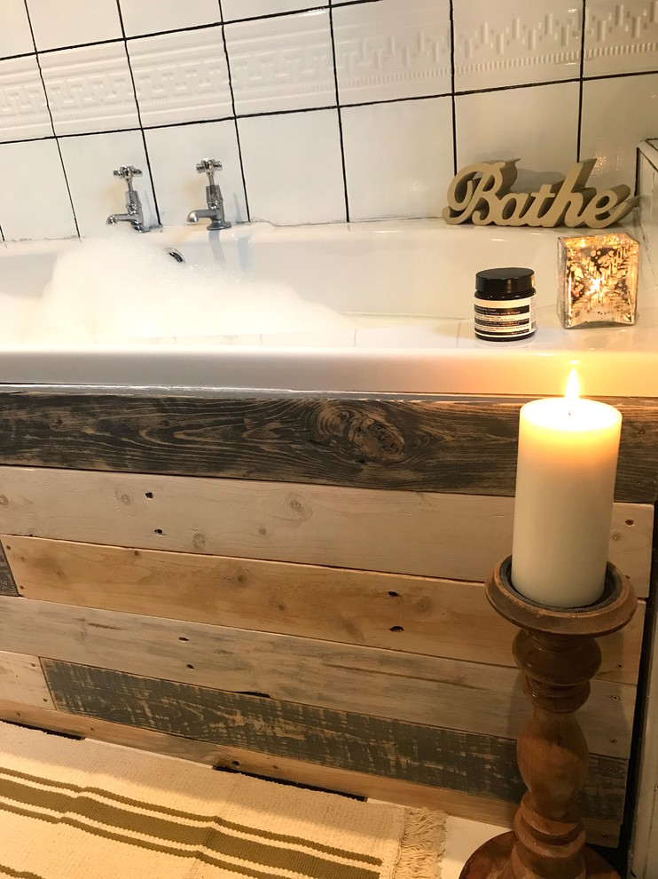 Cette image montre une petite salle de bain chalet pour enfant avec une baignoire posée, un combiné douche/baignoire, un carrelage blanc, des carreaux de céramique et un mur gris.
