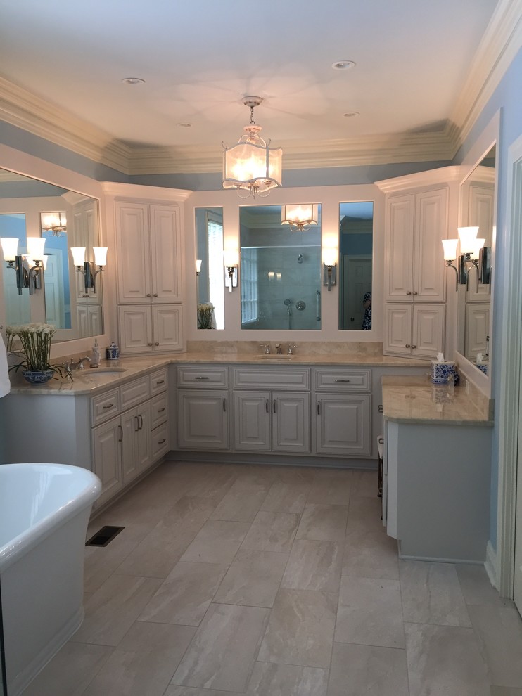 Идея дизайна: большая главная ванная комната в классическом стиле с фасадами с выступающей филенкой, белыми фасадами, отдельно стоящей ванной, угловым душем, раздельным унитазом, бежевой плиткой, разноцветной плиткой, плиткой мозаикой, синими стенами, полом из керамогранита, врезной раковиной и мраморной столешницей