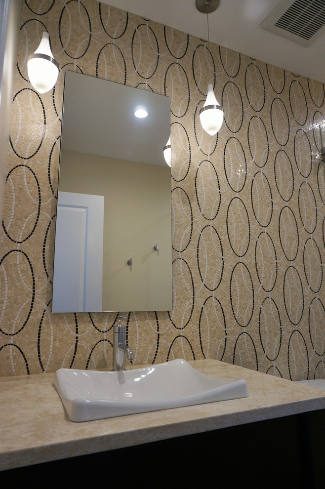 Modern inredning av ett litet badrum med dusch, med ett fristående handfat, möbel-liknande, skåp i mörkt trä, bänkskiva i kalksten, en dusch i en alkov, en toalettstol med hel cisternkåpa, flerfärgad kakel, mosaik, beige väggar och mellanmörkt trägolv