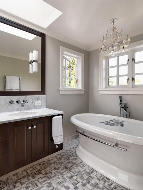 Exemple d'une salle de bain principale chic en bois foncé de taille moyenne avec un lavabo intégré, un placard à porte shaker, une baignoire indépendante, WC à poser, un carrelage gris et un mur gris.