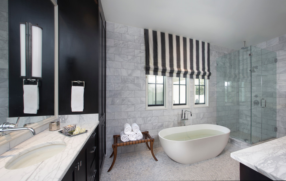Inspiration for a large traditional ensuite bathroom in New Orleans with shaker cabinets, dark wood cabinets, a freestanding bath, a corner shower, white tiles, stone tiles, marble flooring, a submerged sink, marble worktops and a hinged door.