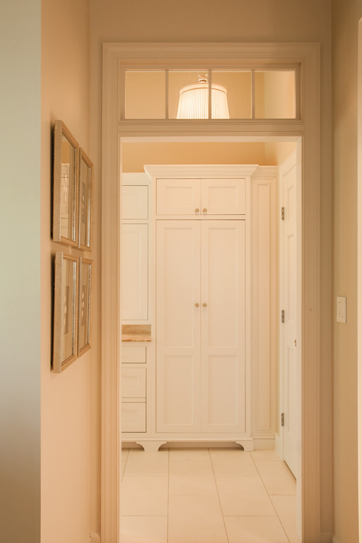 Cette photo montre une salle de bain principale chic avec un placard avec porte à panneau encastré, des portes de placard blanches, un plan de toilette en marbre, un carrelage de pierre, un mur beige et un sol en calcaire.