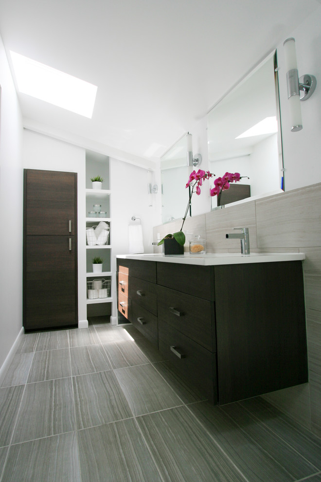 Inredning av ett modernt mellanstort en-suite badrum, med ett undermonterad handfat, släta luckor, skåp i mörkt trä, bänkskiva i kvarts, grå kakel, porslinskakel, vita väggar och klinkergolv i porslin