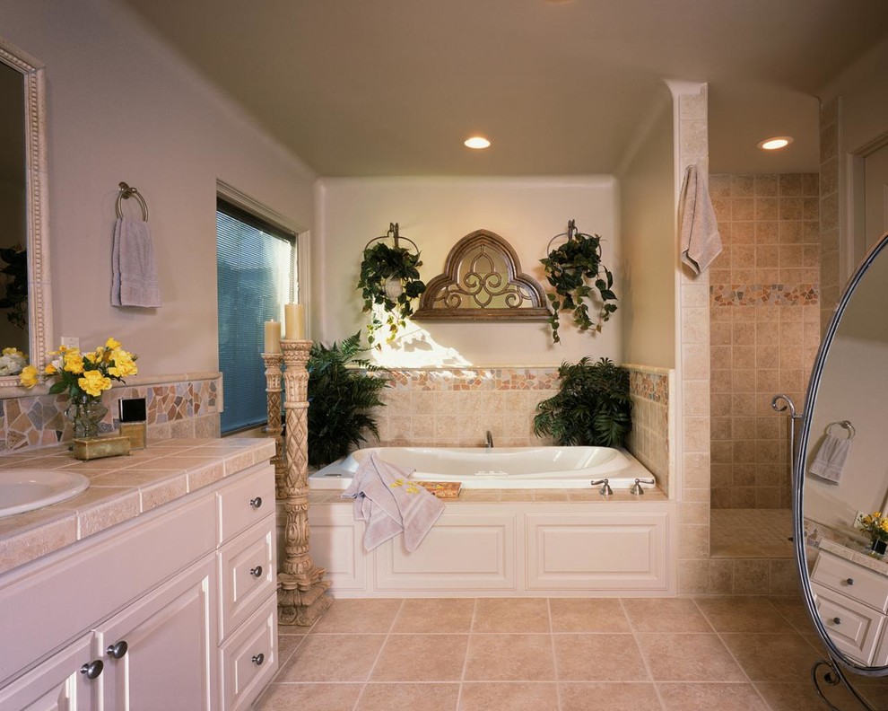 Inredning av ett klassiskt stort en-suite badrum, med luckor med upphöjd panel, vita skåp, ett platsbyggt badkar, en dusch i en alkov, beige kakel, keramikplattor, beige väggar, klinkergolv i porslin, ett nedsänkt handfat, kaklad bänkskiva, beiget golv och med dusch som är öppen