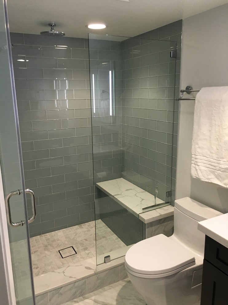 Medium sized contemporary shower room bathroom in Los Angeles with flat-panel cabinets, dark wood cabinets, an alcove shower, a one-piece toilet, green tiles, metro tiles, white walls, marble flooring, a submerged sink and marble worktops.