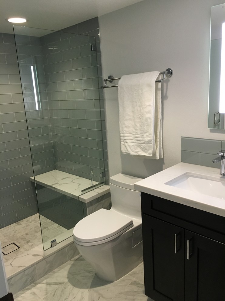 Example of a mid-sized trendy 3/4 green tile and subway tile marble floor alcove shower design in Los Angeles with flat-panel cabinets, dark wood cabinets, a one-piece toilet, white walls, an undermount sink and marble countertops